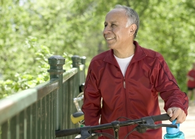 Happy Senior Man in Park with Bike